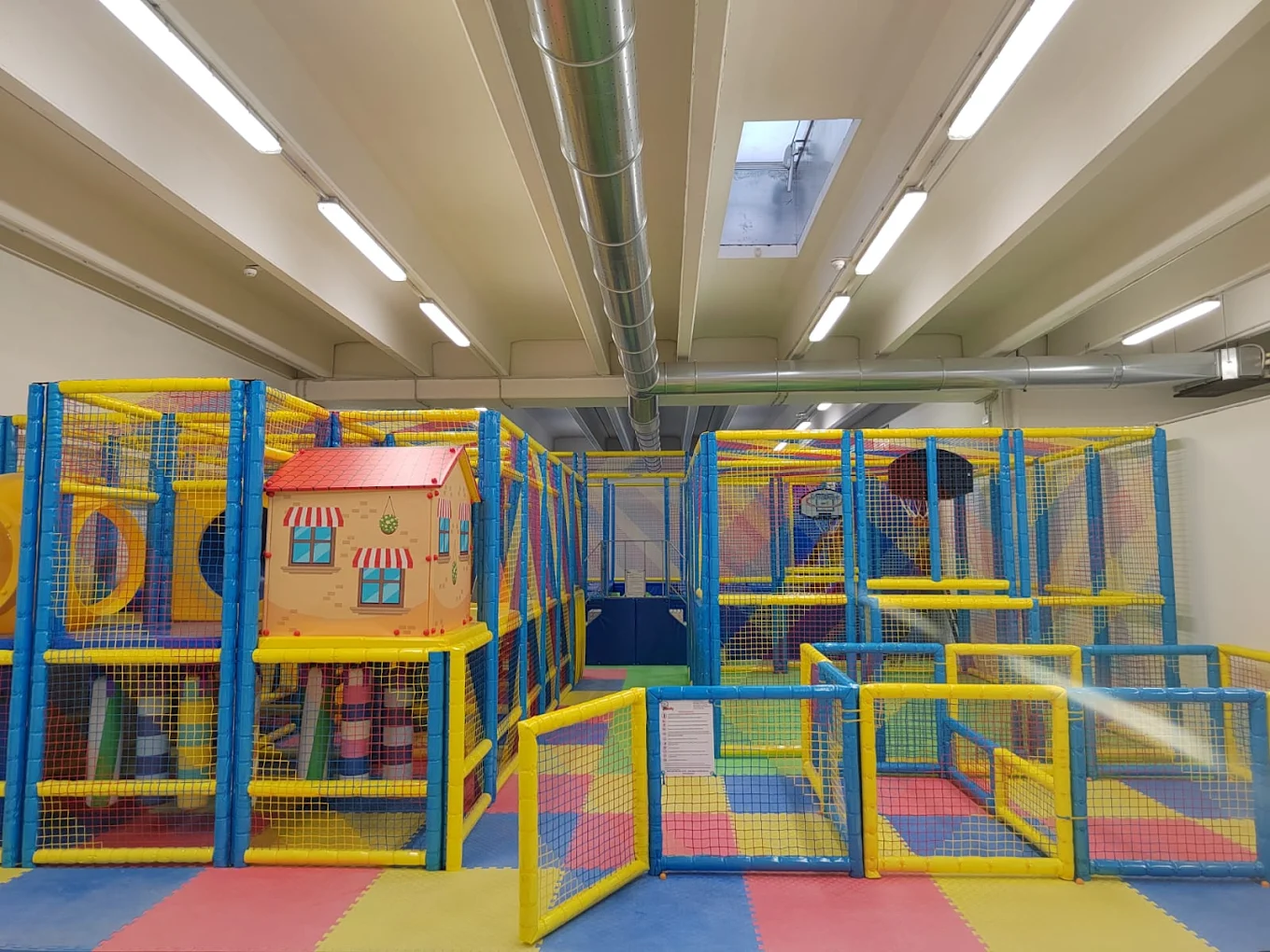 Area giochi colorata con casetta, reti e percorsi per bambini